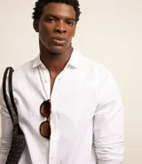 Camisa celeste de lino con cuello camisero, abotonadura frontal y mangas largas.