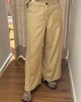 Pantalón ancho color beige, de corte holgado desde la cadera hasta el tobillo.