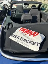 Remera celeste de corte recto y mangas cortas, con estampado en la espalda de cuatro raquetas de pádel rojas y texto en blanco "IBIZA RACKET ITTAI STARS".
