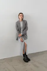 Blazer gris de corte clásico con solapas de muesca, cierre frontal con dos botones y bolsillos laterales con solapa.