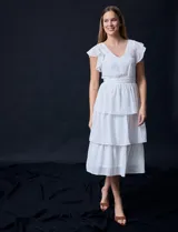 Vestido blanco de gasa con capas de la marca Julia Jordan. Tiene escote en V, mangas cortas con volados, corte en la cintura, abertura central en la espalda con cierre invisible y forro interno a tono.