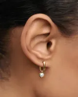 Aros pequeños dorados con colgante de perla cultivada de agua dulce.