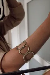 Pulsera rígida dorada con diseño de eslabones ovalados.