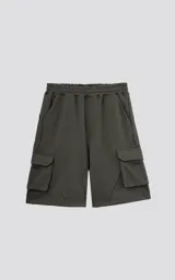 Bermuda de algodón rústico color verde militar, calce oversize, con elástico en la cintura y bolsillos cargo con cierre.