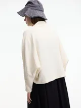 Saco color beige de algodón, con bolsillos laterales y mangas amplias.