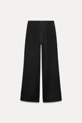 Pantalón negro de pierna ancha confeccionado en tejido de punto canalé con algodón. Tiene tiro medio y cintura con elástico interior.