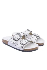 Sandalias blancas con doble tira y hebillas plateadas, adornadas con tachas redondas plateadas.