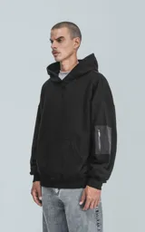 Hoodie negro oversize de rústico 100% algodón con capucha forrada y bolsillo tipo bomber con cierre en la manga.