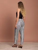 Pantalón largo de lino y rayón a rayas verticales grises y blancas. Tiene pretina elastizada con lazo de ajuste, bolsillos delanteros y traseros.