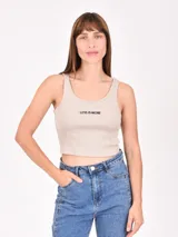 Musculosa corta color beige con cuello redondo y estampado con la frase "Less is more".