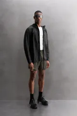 Shorts de running negros confeccionados en tejido técnico ligero y elástico, con malla interior, cintura elástica ajustable con cordón, bolsillo trasero con cierre y perforaciones en las perneras.