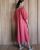 Vestido midi celeste de denim, con escote con lazo, mangas 3/4 abullonadas y corte evasé.