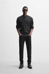 Pantalón de jean azul oscuro, corte slim fit, tiro medio, cinco bolsillos, tejido elástico y efecto lavado.