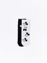 Pack de dos pares de medias de algodón, uno negro con el contorno de la cara de Mickey Mouse en blanco y otro blanco con la cara de Mickey Mouse en negro.