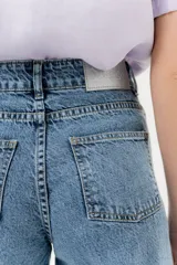 Pantalón jean wide leg de tiro alto, color azul denim, con ruedo desflecado y bolsillos delanteros y traseros.