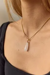 Collar dorado con cadena fina y dije colgante en forma de lágrima de piedra natural azul con vetas blancas.