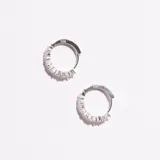 Aros tipo argolla de plata enchapada, engarzados con piedras de circonia transparentes en forma de pera y redondas.