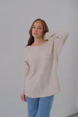 Sweater color beige de punto con cuello redondo y corte recto.