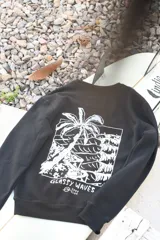 Buzo negro de algodón con estampa blanca en la espalda de una palmera y el texto "Glassy Waves Surf Club".