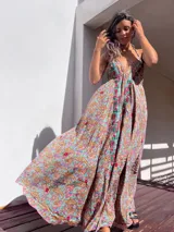 Vestido largo con estampado paisley en tonos marrones, celestes, dorados y fucsias. Tiene escote halter con tirantes finos y bordados rojos en el frente.