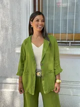 Blazer de lino color verde pistacho, de corte relajado y manga larga remangada. Presenta solapas anchas, cierre frontal con dos botones y bolsillos de parche.