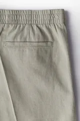 Short color gris claro confeccionado en mezcla de lino y algodón, corte regular, con cintura elástica, bolsillos laterales y trasero.