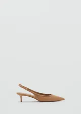Zapato destalonado color beige con punta fina, detalle de tachuelas y cierre de hebilla. El tacón mide 4,5 cm.