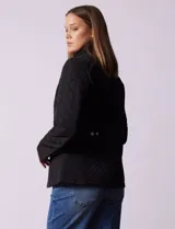 Campera negra capitoneada marca Gallery, con cierre central, bolsillos frontales con cierre, cintura con cinto de ajuste regulable y forro interno a tono.