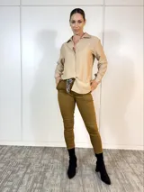 Pantalón de vestir color camel, de corte recto, con cintura plisada, bolsillos laterales y traseros. Se ajusta a la cintura con cinturón de animal print.
