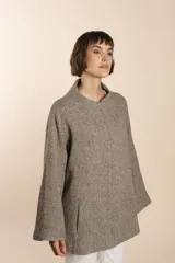 Capa marrón de lana con bolsillos laterales, mangas amplias y pinzas en la delantera.