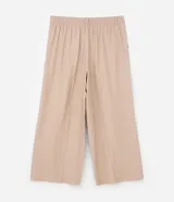 Pantalón de corte ancho confeccionado en sastrería de viscosa color beige, con cintura alta, trabillas, cierre con botón forrado y bolsillos laterales.