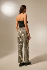Pantalón de algodón con estampado de piel de serpiente en tonos beige y negro, corte recto y tiro alto.