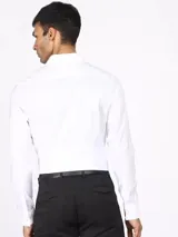 Camisa de vestir blanca de manga larga, con cuello clásico y cierre con botones.
