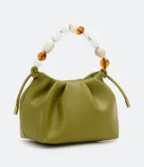 Bolso pequeño color verde oliva, desestructurado, con pinzas frontales y cierre de botón a presión. Incluye una correa de hombro extraíble y un asa de mano decorada con cuentas acrílicas variadas en tonos blancos, marrones y transparentes.
