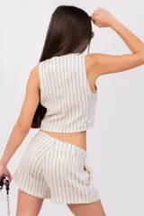 Short de vestir color gris con finas rayas verticales blancas, tiro alto, pinzas delanteras, bolsillos laterales y ruedo con dobladillo. Cierre frontal con botón y cremallera.