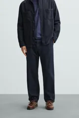 Pantalón azul marino de corte recto, confeccionado en tejido de algodón y lino. Tiene cintura elástica ajustable con cordón, bolsillos delanteros y traseros de vivo.