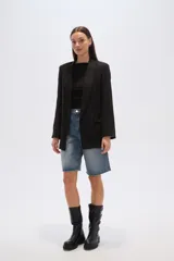 Blazer color beige, de corte holgado, con solapas anchas y bolsillos frontales.