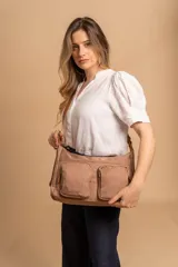 Bandolera de tafeta impermeable, liviana, con dos compartimientos principales, dos bolsillos con cierre y correa regulable con hebilla.