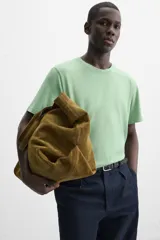 Camiseta verde de algodón, corte relaxed fit, cuello redondo y mangas cortas. Tiene un efecto de lavado que le da una apariencia única.