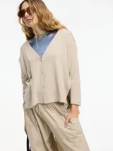 Cardigan negro de tejido con botones en la parte delantera y tajos verticales laterales.