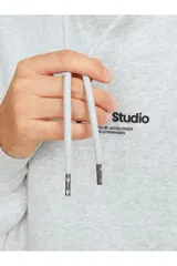 Canguro gris melange de manga larga con capucha, corte relajado y bolsillo tipo canguro. Estampado en relieve con efecto tridimensional.