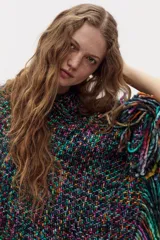 Poncho tejido plano de lana merino multicolor con escote en V y flecos bordados a mano en el ruedo.