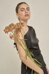 Top negro de un hombro con manga larga acampanada y corte ajustado.