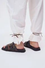 Sandalias de cuero marrón con tres tiras anchas y hebillas doradas.