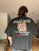 Remera marrón con estampado de un reloj dorado y la frase "Who wears a watch in Ibiza?".