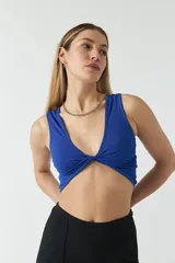 Top azul eléctrico de punto canalé, con escote en V y diseño cruzado con nudo en el centro.