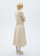 Sweater color beige de tejido de punto con cuello alto y mangas largas.
