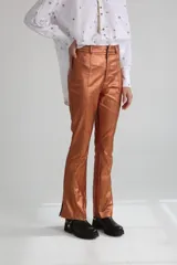 Pantalón de vestir color cobre con acabado brillante, corte recto y aberturas en el ruedo.