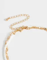 Collar corto multicadena, con una cadena dorada de eslabones grandes y otra de mostacillas blancas, con dije de cerezas rojas y hojas verdes hechas de mostacillas.