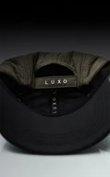 Gorra de cinco paneles color verde militar con visera negra y logo bordado en el frente.